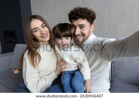 family, holidays and people concept - portrait of happy mother, father and little son taking selfie on birthday at home party