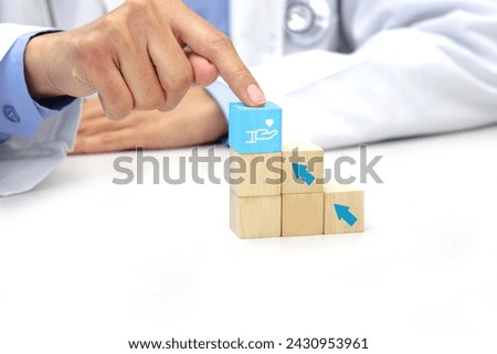 Finger of doctor touching a wooden block cube with medical icon symbol. Medical, health and insurance concept.