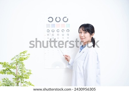 A female doctor standing in front of an eye test chart
