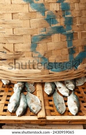 a bunch of dried salted fish are ready to packing in wooden basket
