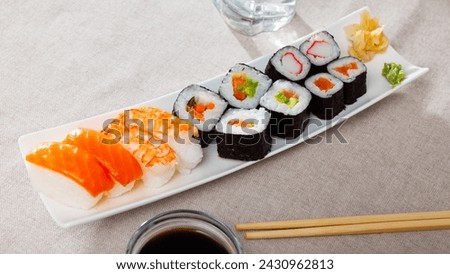 Assorted sushi set from makizushi, hosomaki and nigirizushi served on white plate with wasabi and pickled ginger. Popular Japanese dish.. Royalty-Free Stock Photo #2430962813