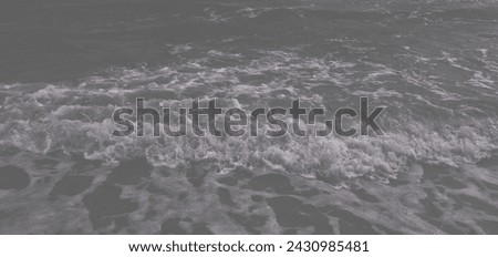 A world without color. Black and white photo of sea waves. Blurred background of sea wave ripples on the beach.