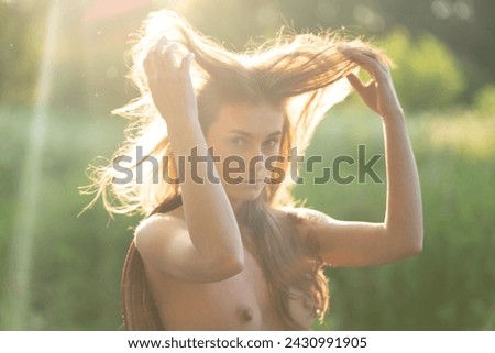 young beautiful woman stands in a field in summer
