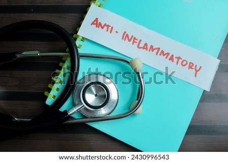 Concept of Anti - Inflammatory write on sticky notes with stethoscope isolated on Wooden Table. Royalty-Free Stock Photo #2430996543
