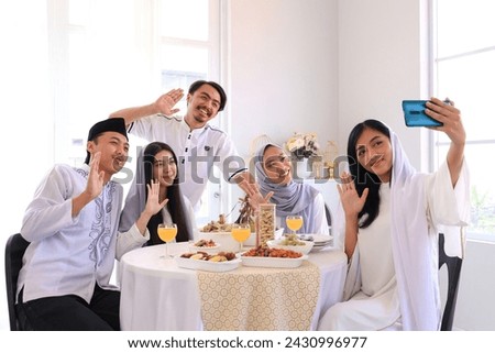 A Group of Asian Friends Taking Selfie Photo during Eid Al Fitr Celebration  Royalty-Free Stock Photo #2430996977