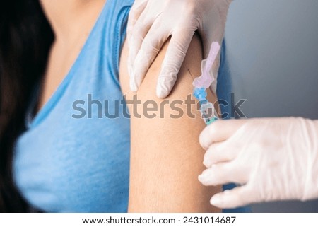 Vaccine in injection needle. Doctor working with patient's arm. Physician or nurse giving vaccination and immunity to virus, influenza or HPV with syringe. Appointment with medical expert. Close-up