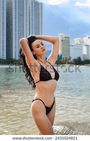 Young ukrainian woman in bikini standing against cityscape of Nha Trang, Vietnam