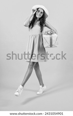 photo of carefree birthday woman hold present. birthday woman hold present isolated on yellow.