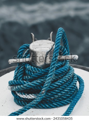 Close-up of mooring bollard with blue rope on a white ship