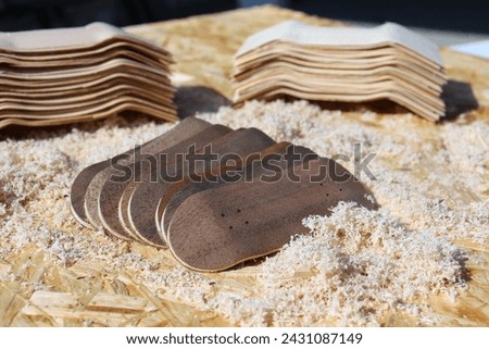 Handmade blank wooden dingerboards with wood shavings on the background, close up. Mini skateboard, small skateboard deck