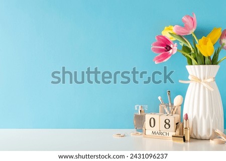 8th March theme: A side view table adorned with women's essentials— jewelry, makeup brushes, red lipstick, fragrance, and calendar set to March 8th, beside vase of tulips against a soft blue backdrop Royalty-Free Stock Photo #2431096237
