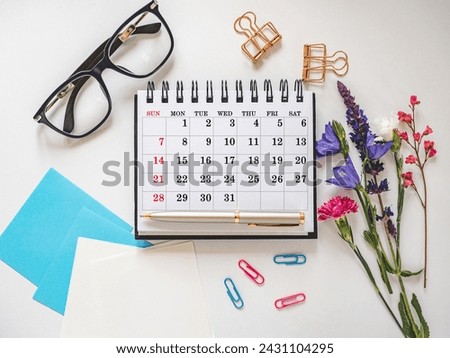 Calendar lies on the table in the office. Daylight. Close-up, indoors. Studio shot. Finance and business concept. Planning working hours and working day
