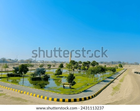 Picture of a Public Park full of green plants and trees including a hut , beautiful view of nature greenry with blue sky.