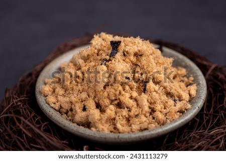 Refined fish floss in a cup against a dark background Royalty-Free Stock Photo #2431113279