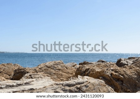 Seascape - huge stones of the coast in the foreground are covered by a sea wave