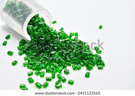 Transparent green masterbatch granules on a white background, this polymer is a colorant for products in the plastics industry Royalty-Free Stock Photo #2431123565