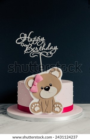 Teddy bear birthday cake on a black background with text Happy Birthday