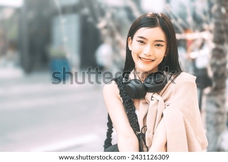 Urban teenager gen z lifestyles concept. Portrait of youth asian woman looking at camera wearing headphone. Joy and Positive look enhance self love.