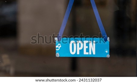 An open business sign hanging in a shop window	

