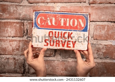 Quick Survey. Caution sign in a woman's hand on a brick background.