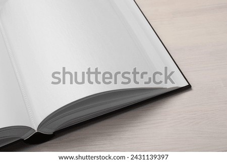 One open photo album on wooden table, above view