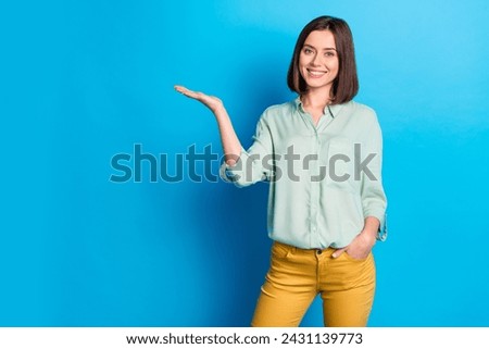 Photo of gorgeous woman with bob hairstyle dressed turquoise shirt palm demonstrate offer empty space isolated on blue color background
