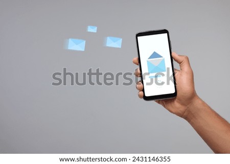 Got new message. Man holding smartphone on grey background, closeup. Space for text