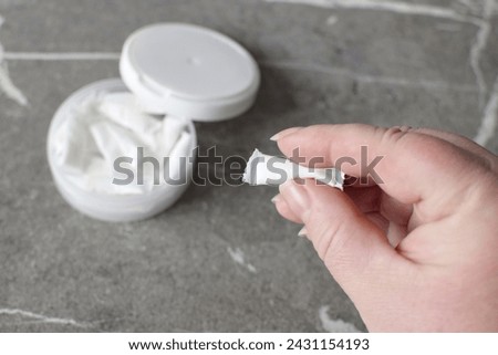 A box of snus pads replaces smokeless cigarettes. Swedish nicotine pouch. A woman holds one bag of snus in her hand. Royalty-Free Stock Photo #2431154193