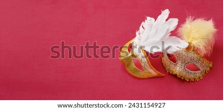 Beautiful white and gold carnival masks on a pink background. Purim, Mardi Gras holiday concept. View from above
