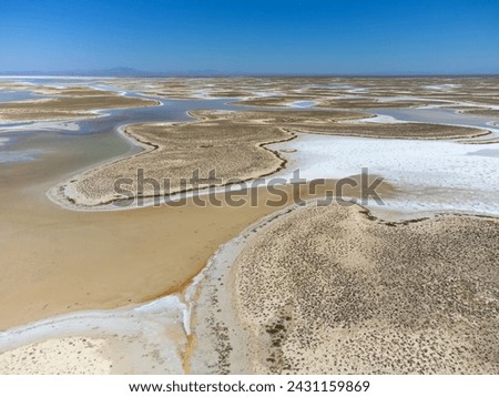 Drone view of dead salt lake Tuz in Turkey. Landscape is like on Moon or Mars, everything dried covered with salt. Here, edible salt is extracted and processed in factory or factory. Alien landscape. Royalty-Free Stock Photo #2431159869