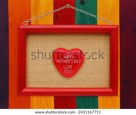 The image is of a red wooden sign on a door with the message "HAPPY MOTHER'S DAY LOVE YOU!" written on it. It is indoors.