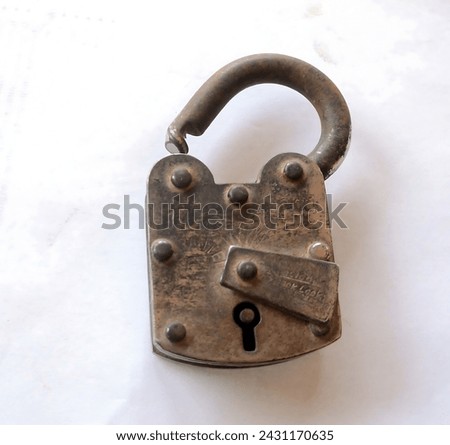 An ancient iron lock, weathered by time, with intricate patterns and rusted edges. Its keyhole, once shiny, is now dull and worn. The lock exudes a sense of history and mystery, hinting at the secrets Royalty-Free Stock Photo #2431170635