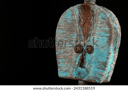 Close up of a wooden Kota reliquary figure from Gabon, isolated on a black background. Tribal African art, showcasing masterful craftsmanship and spiritual symbolism. Royalty-Free Stock Photo #2431188519
