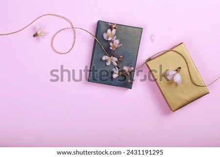 Multipurpose composition, branch of cherry blossoms on a present wrapped in blue and gold paper. International Women's day greeting. Copy space, close up, top view, flat lay, background.