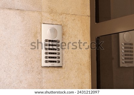 Outdoor intercom outside a residential building with empty name tag cards. Silver modern doorbells with blank nameplates suitable for adding text. European intercom communication system.