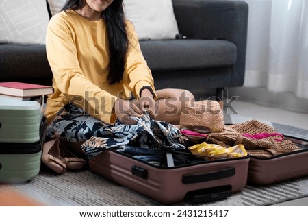 Woman puts clothes in a bag and prepares to go on vacation.