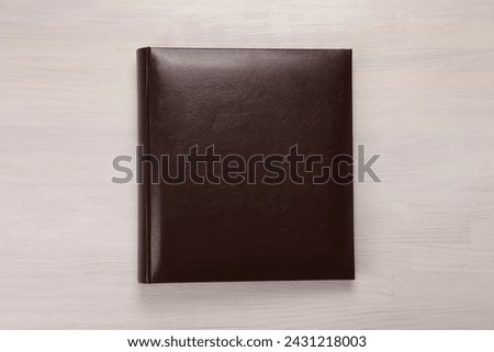 One photo album on wooden table, top view