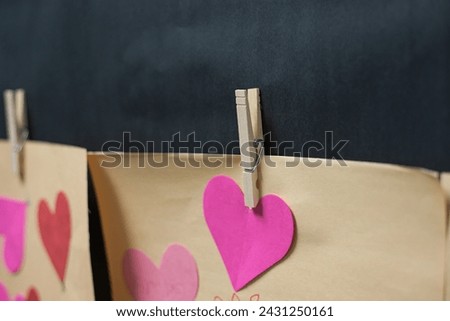 Cute heart shape paper crafts rope hanging attached clip outside classroom wall for Valentine Day celebration at preschool kindergarten in Dallas, Texas, romance decor idea little kid students. USA