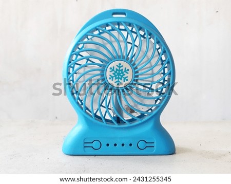 A dirty blue mini portable fan that has not been cleaned, on a white background. Royalty-Free Stock Photo #2431255345