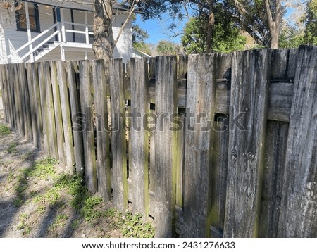 Old weathered vintage shadow box fence and home with stairs