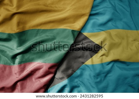 big waving national colorful flag of bahamas and national flag of lithuania . macro