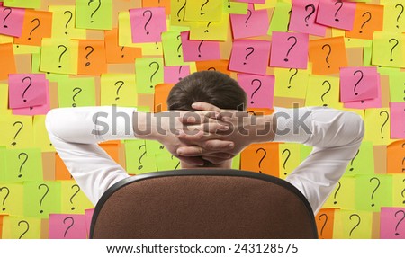 Businessman sitting in a chair, and solves the problem Royalty-Free Stock Photo #243128575