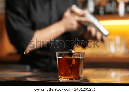 Bartender making cocktail at bar counter. Barman shaking cocktail shaker bottle, close-up Royalty-Free Stock Photo #2431293291