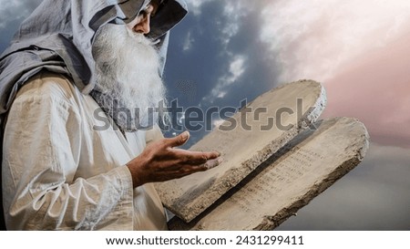 prophet Moses holds the tablets with the ten commandments (The tablets contain a quote from the Bible, in Hebrew, translates as Do not take a life , Follow God's path) Royalty-Free Stock Photo #2431299411