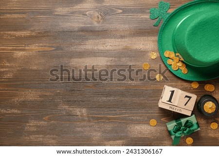 Gift box with leprechaun hat, calendar and pot of golden coins for St. Patrick's Day celebration on wooden background