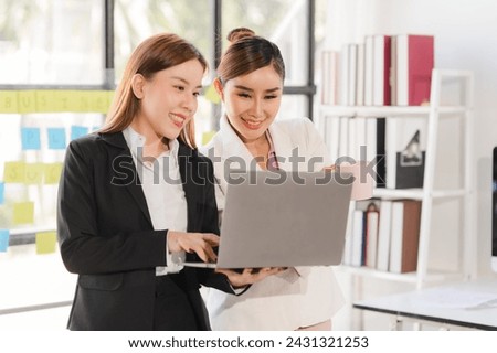 Businesswoman leading team meeting and using tablet and laptop computer with financial in co working office