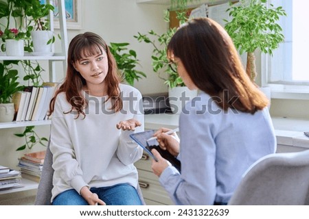 Teenage girl at therapy session with mental health professional Royalty-Free Stock Photo #2431322639