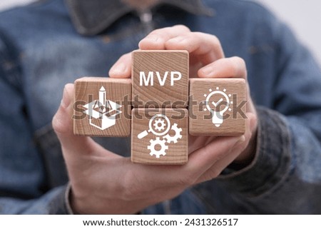 Man holding wooden cubes sees abbreviation: MVP. Minimum Viable Product ( MVP ) Business concept for lean startup. Life cycle of product development. Analysis and market validation. Royalty-Free Stock Photo #2431326517