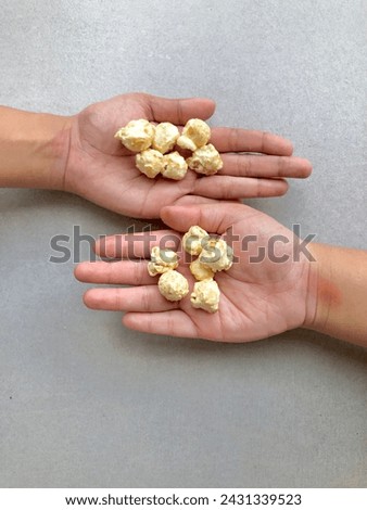 Hand have some popcorn on their palm. Vertical photo.