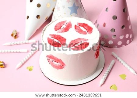 Colorful cake decorated with red lips and candles, hats on color background